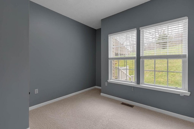 unfurnished room with carpet flooring and baseboards