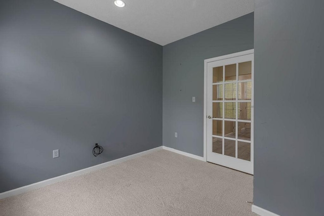carpeted empty room featuring baseboards and recessed lighting