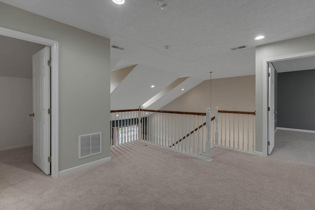 hallway featuring carpet, baseboards, recessed lighting, a textured ceiling, and an upstairs landing