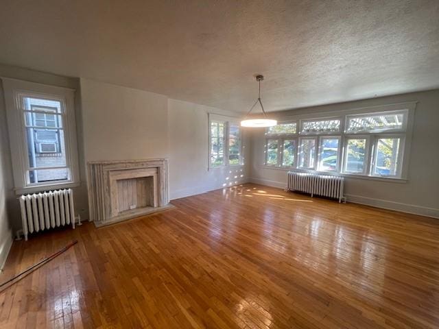 6605 Woodwell St, Squirrel Hill, PA 15217 - unfurnished living room featuring wood-type flooring, a wealth of natural light, and radiator heating unit