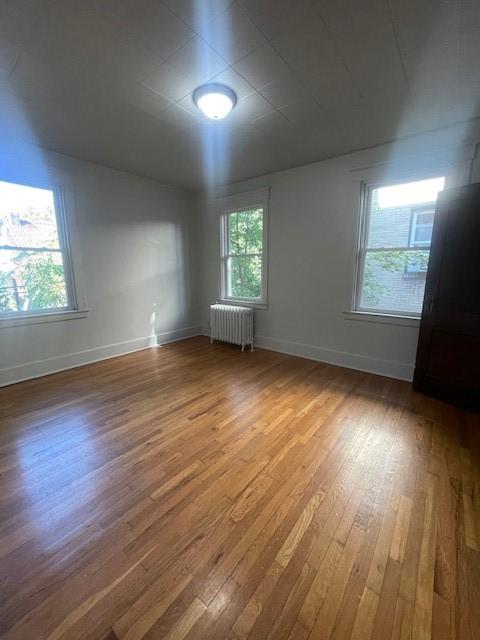 6605 Woodwell St, Squirrel Hill, PA 15217 - empty room with radiator heating unit, baseboards, and wood finished floors