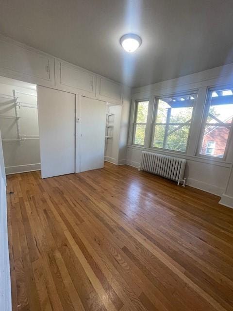 6605 Woodwell St, Squirrel Hill, PA 15217 - unfurnished bedroom featuring multiple windows, radiator heating unit, and wood finished floors