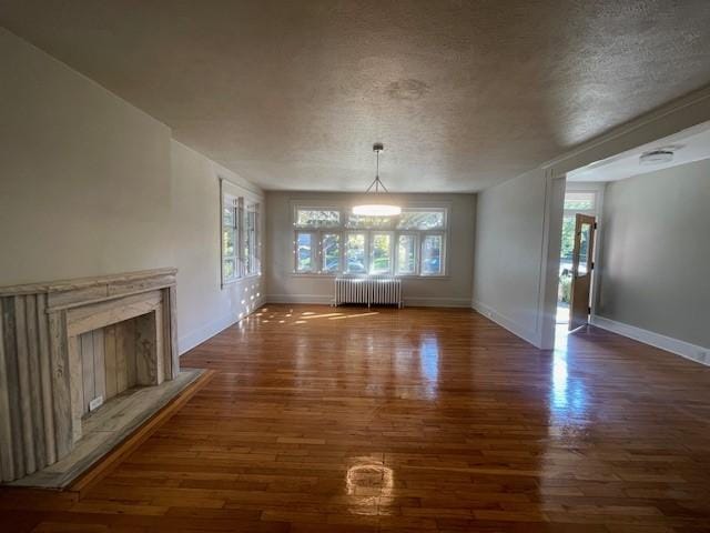6605 Woodwell St, Squirrel Hill, PA 15217 - unfurnished living room with radiator, a textured ceiling, wood finished floors, and a wealth of natural light