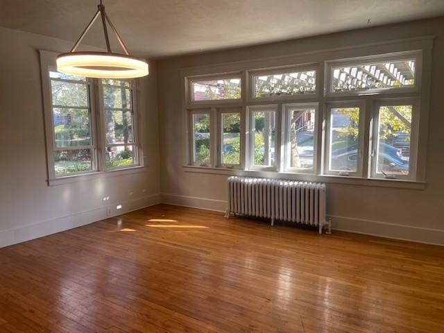 6605 Woodwell St, Squirrel Hill, PA 15217 - unfurnished dining area with baseboards, radiator heating unit, and wood finished floors
