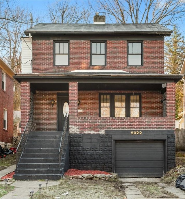traditional-style house with a garage, brick siding, and a chimney