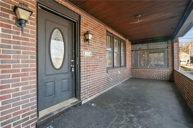 property entrance with covered porch and brick siding