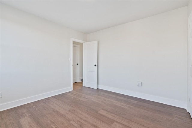 unfurnished room with wood finished floors and baseboards