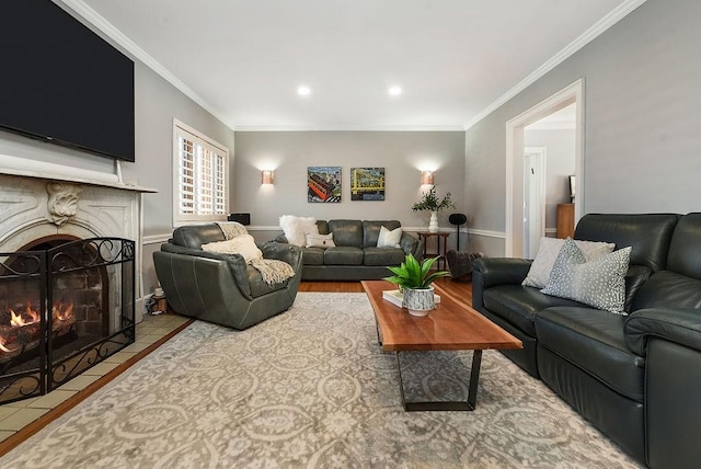 living area featuring a fireplace with flush hearth, crown molding, and recessed lighting