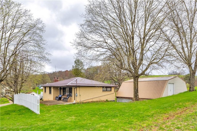 back of property with a yard, a patio, a chimney, and fence