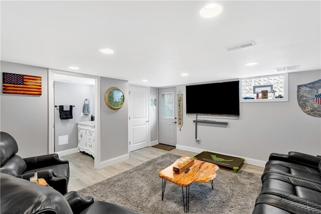 living area featuring baseboards, light wood-style floors, visible vents, and recessed lighting
