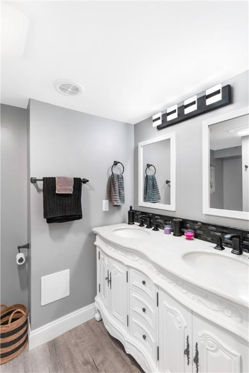 full bathroom featuring double vanity, visible vents, baseboards, and a sink