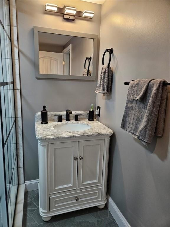bathroom with baseboards, vanity, and tile patterned flooring