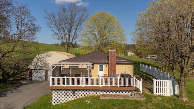 back of property featuring a chimney, fence, a yard, a wooden deck, and brick siding