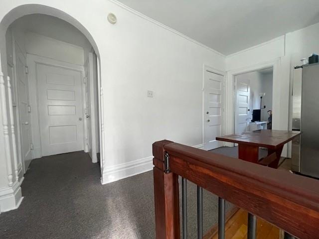 hallway with baseboards and arched walkways