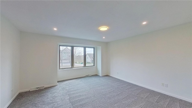 spare room featuring visible vents, recessed lighting, carpet, and baseboards