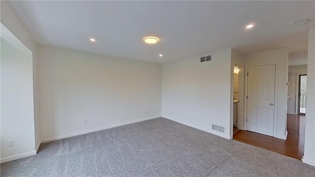 empty room featuring recessed lighting, baseboards, visible vents, and dark carpet