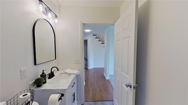 bathroom featuring vanity, baseboards, and wood finished floors
