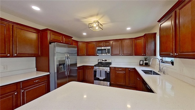kitchen featuring light countertops, stainless steel appliances, recessed lighting, and a sink