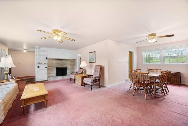 carpeted living area with baseboards, a fireplace with raised hearth, and ceiling fan