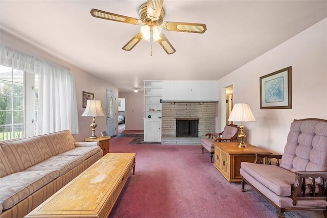 living room with a stone fireplace, carpet flooring, and a ceiling fan