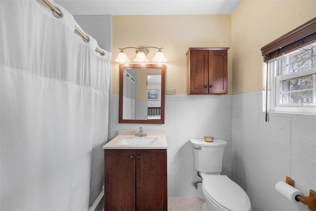 bathroom featuring a wainscoted wall, toilet, tile walls, curtained shower, and vanity