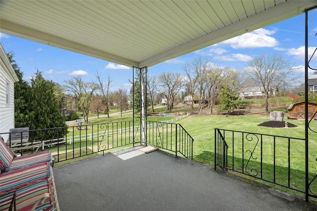 view of patio with an outdoor structure and a storage unit