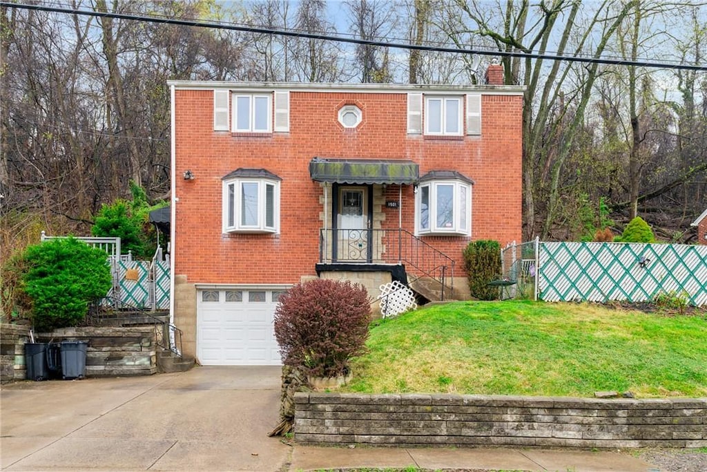 1501 Laketon Rd, Wilkinsburg, PA 15221 - view of front of home with a front lawn, a chimney, concrete driveway, brick siding, and an attached garage