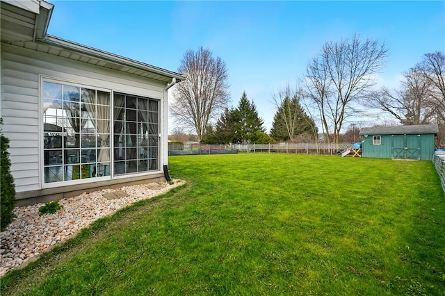 view of yard with fence, an outbuilding, and a storage unit