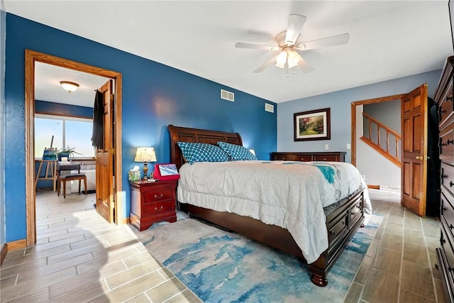 bedroom featuring visible vents, baseboards, a ceiling fan, and wood tiled floor