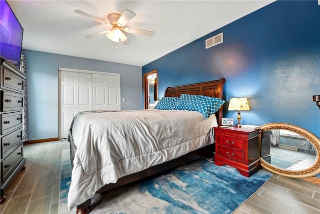 bedroom featuring ceiling fan, visible vents, a closet, and wood tiled floor