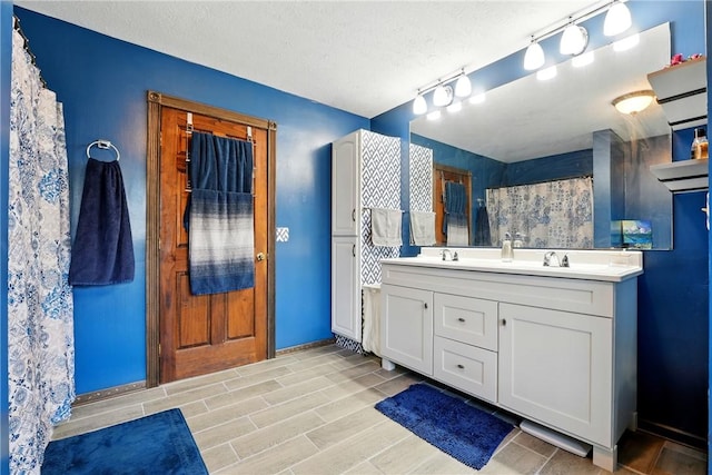 bathroom featuring a shower with shower curtain, double vanity, wood finish floors, and a sink