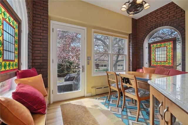 5818 Aylesboro Ave, Squirrel Hill, PA 15217 - dining room featuring brick wall, wood finished floors, and a baseboard heating unit