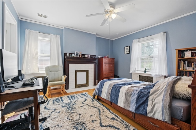 bedroom with ornamental molding, wood finished floors, a desk, and ceiling fan