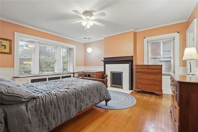 5818 Aylesboro Ave, Squirrel Hill, PA 15217 - bedroom with crown molding, wainscoting, light wood finished floors, a fireplace, and a ceiling fan