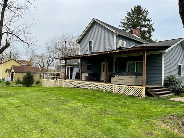back of property with a yard, a deck, a hot tub, and a chimney