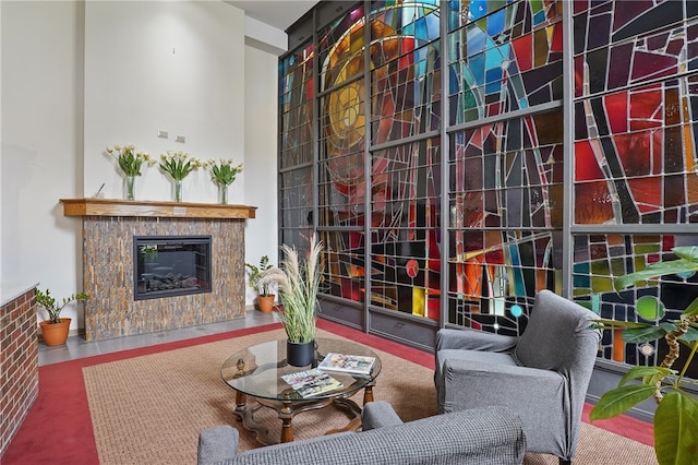 interior space featuring a glass covered fireplace and a high ceiling