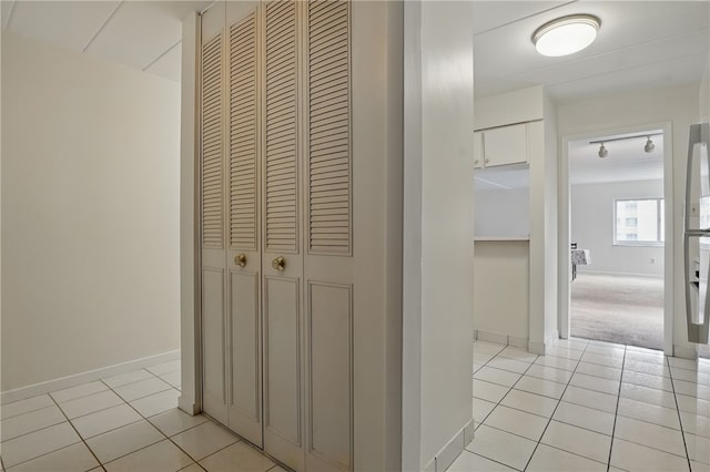 corridor with baseboards and light tile patterned floors
