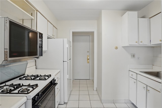 kitchen featuring light countertops, gas stove, and white cabinets