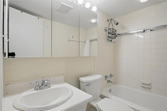 bathroom with toilet, a sink, visible vents, and shower / bathing tub combination