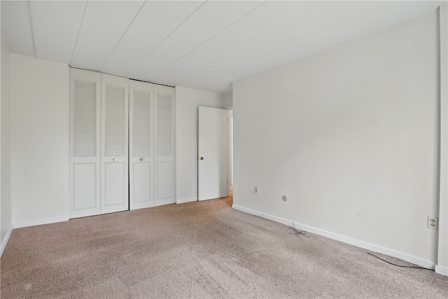 unfurnished bedroom featuring a closet, carpet flooring, and baseboards
