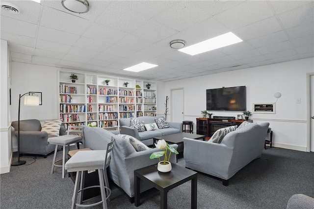 living room featuring carpet floors, visible vents, and a paneled ceiling