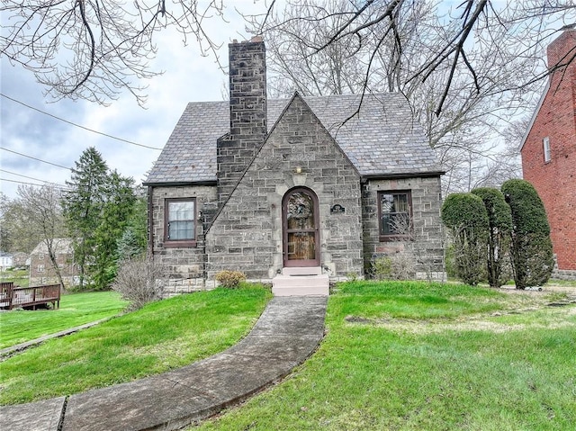 120 Arden Dr, Shaler, PA 15116 - tudor-style house with a chimney, a high end roof, stone siding, and a front lawn