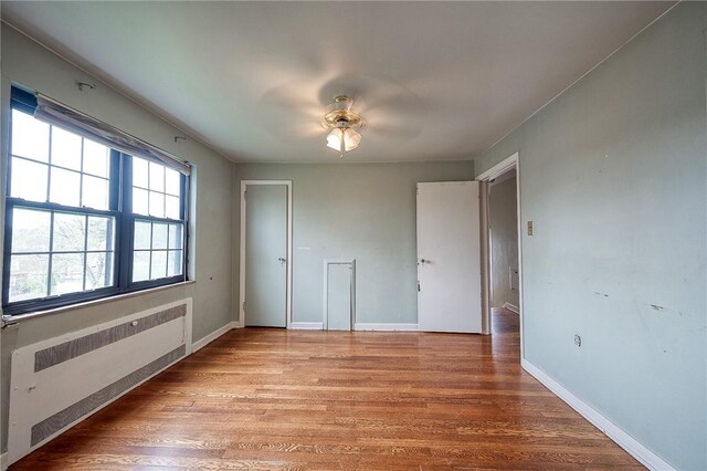 120 Arden Dr, Shaler, PA 15116 - unfurnished bedroom featuring ceiling fan, baseboards, radiator heating unit, and wood finished floors
