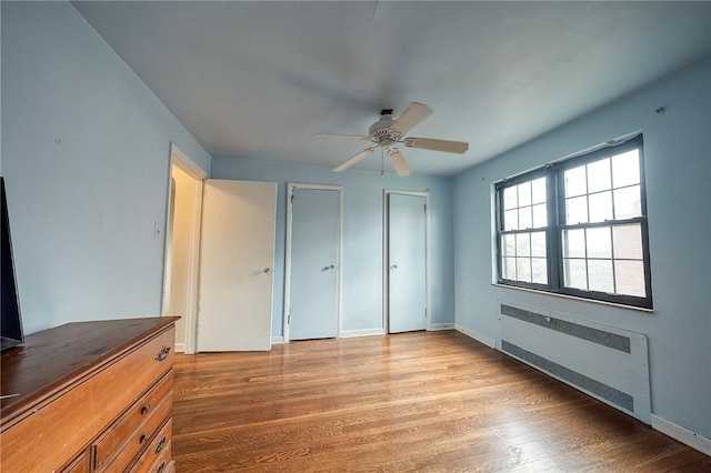 120 Arden Dr, Shaler, PA 15116 - unfurnished bedroom with radiator heating unit, light wood finished floors, baseboards, two closets, and ceiling fan