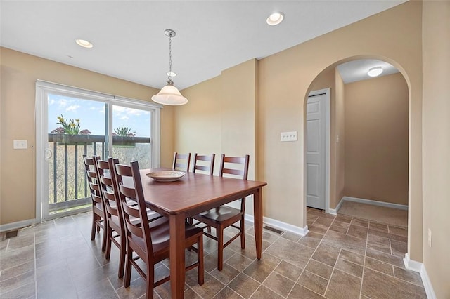 dining room featuring recessed lighting, arched walkways, and baseboards