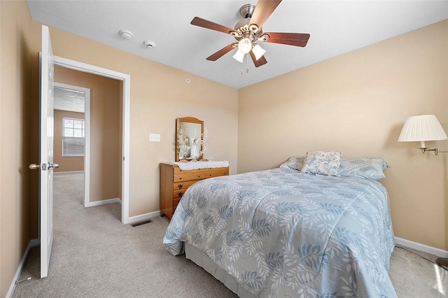 bedroom with a ceiling fan, visible vents, light colored carpet, and baseboards