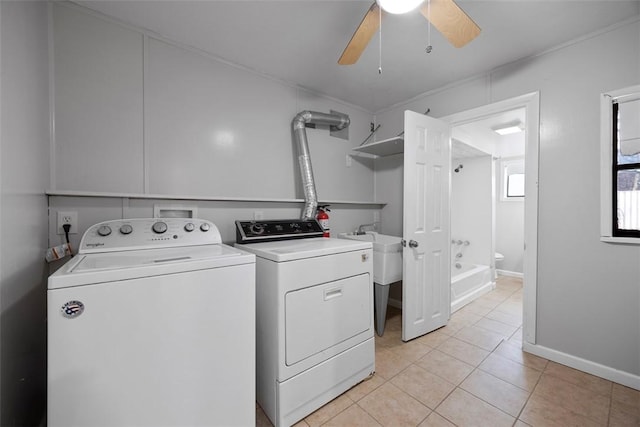 clothes washing area with baseboards, ceiling fan, washer and dryer, laundry area, and light tile patterned floors