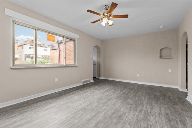 138 W Larkspur St, Munhall, PA 15120 - empty room with arched walkways, wood finished floors, visible vents, and a ceiling fan
