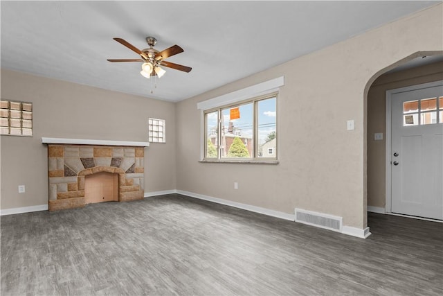 138 W Larkspur St, Munhall, PA 15120 - unfurnished living room with arched walkways, visible vents, wood finished floors, ceiling fan, and a fireplace