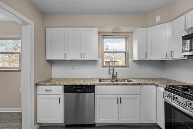 138 W Larkspur St, Munhall, PA 15120 - kitchen featuring white cabinets, backsplash, appliances with stainless steel finishes, and a sink
